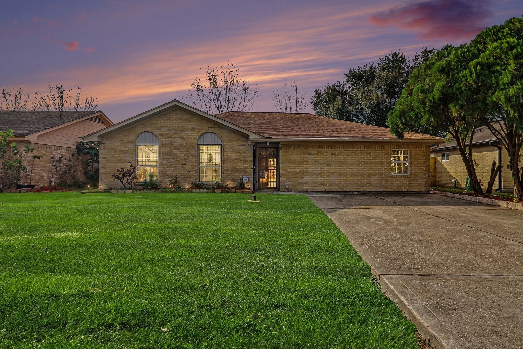8138 Constellation Lane Houston, TX 77075 - Photo 1 of 16 a front view of a house with a garden and trees