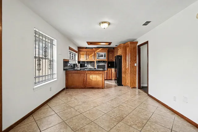 a view of kitchen with furniture and refrigerator