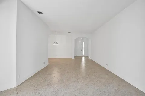 a view of a hallway with wooden floor and a bathroom