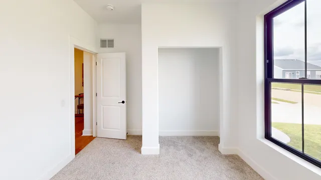 a bedroom with a bed and a large window