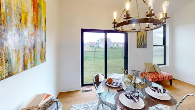 a kitchen with stainless steel appliances kitchen island granite countertop a refrigerator a stove a microwave oven a dining table and chairs with wooden floor