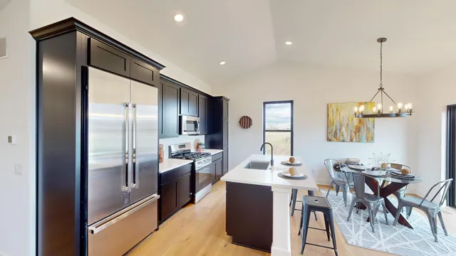 a kitchen with stainless steel appliances kitchen island granite countertop a refrigerator a stove a kitchen island a dining table and chairs with wooden floor