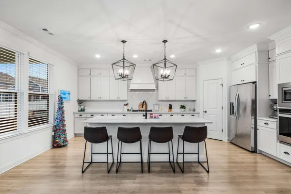 a kitchen with stainless steel appliances kitchen island granite countertop a sink and a refrigerator
