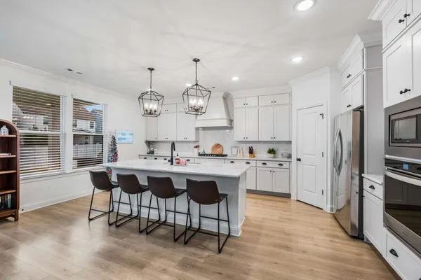 a kitchen with stainless steel appliances a dining table and chairs