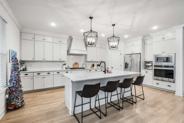a kitchen that has a lot of cabinets in it and stainless steel appliances