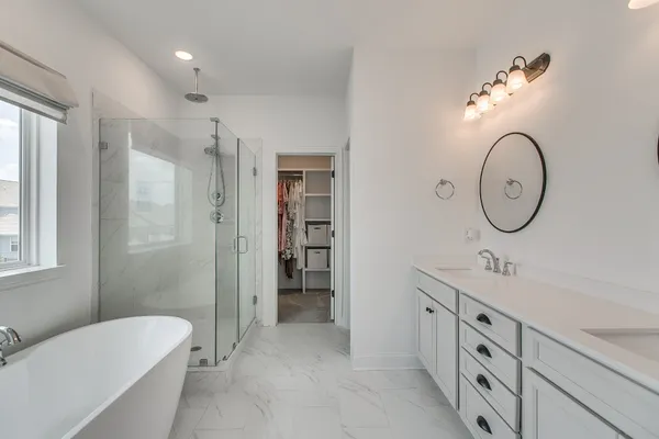 a spacious bathroom with a double vanity sink mirror and a bathtub