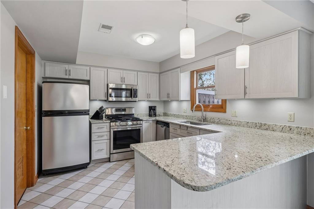 416 Chandler Place Pittsburgh, PA 15212 - Photo 15 of 38 a kitchen with stainless steel appliances granite countertop a sink a stove a refrigerator a center island and cabinets