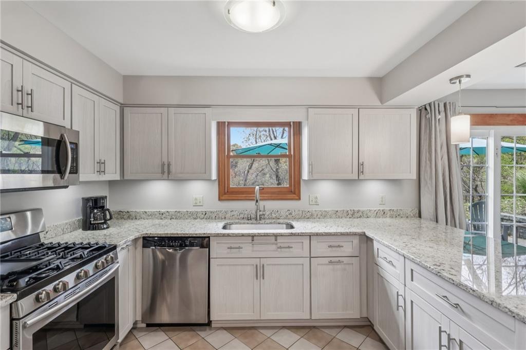 416 Chandler Place Pittsburgh, PA 15212 - Photo 16 of 38 a kitchen with granite countertop a stove sink and cabinets