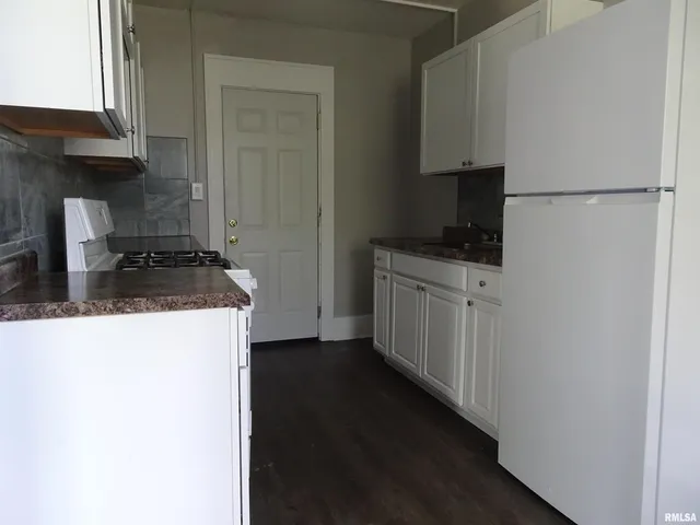 a kitchen with a refrigerator and a stove top oven
