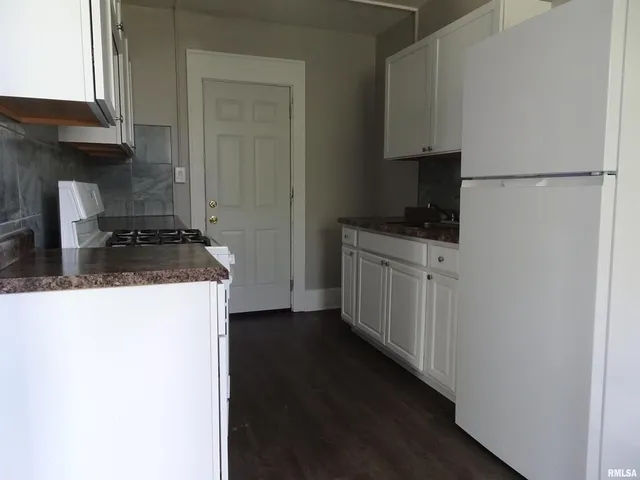 an empty room with wooden floor and a window