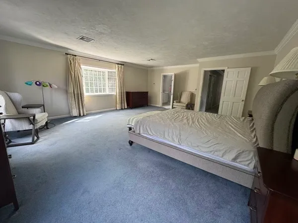 a bedroom with a bed chair and window