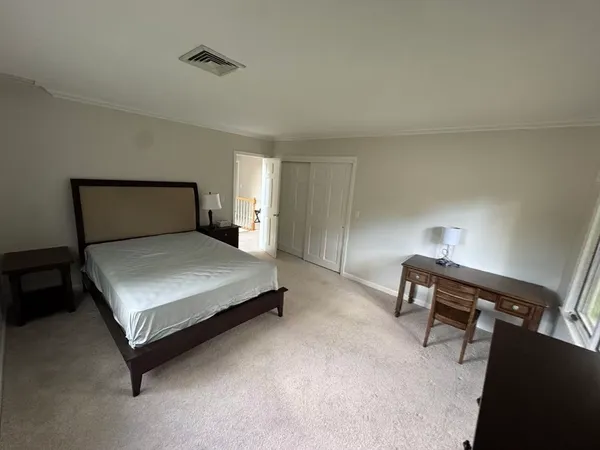 a bedroom with a bed and a lamp on desk