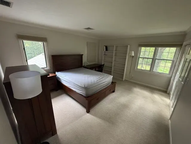 a bedroom with a bed chair and a window