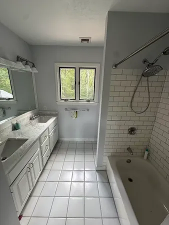 a bathroom with a sink a toilet a mirror and bathtub