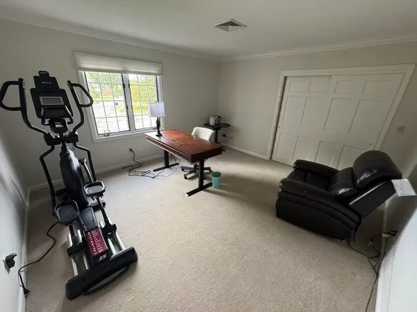 a living room with furniture gym equipment and a window