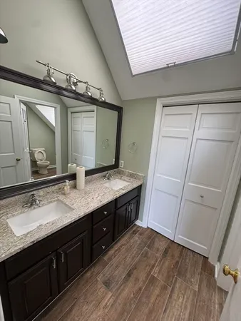a spacious bathroom with a granite countertop sink and a mirror