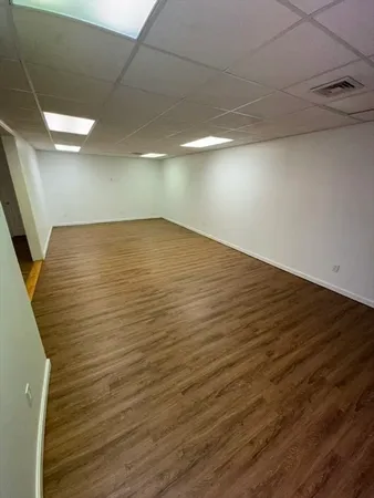 a view of empty room with wooden floor