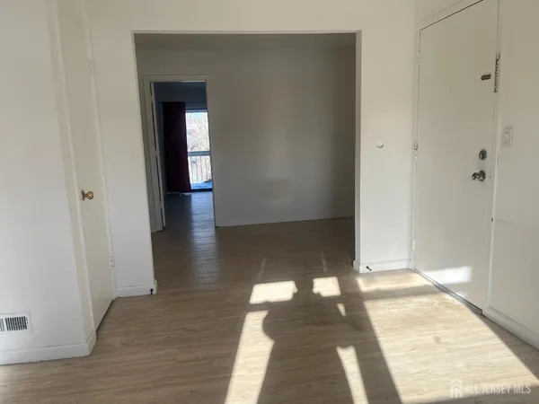 a view of a hallway with wooden floor and glass door