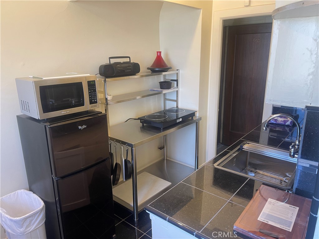 315 West 3rd Street, Unit 710 Long Beach, CA 90802 - Photo 6 of 14 a kitchen with a refrigerator and a sink