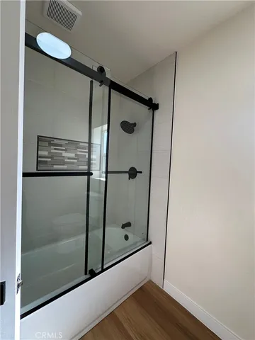 a bathroom with a shower and a glass door