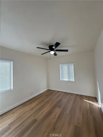 a view of a livingroom with a ceiling fan and wooden floor