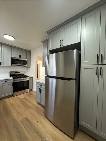a kitchen with stainless steel appliances a refrigerator and a stove top oven