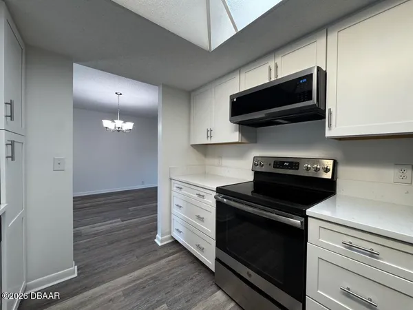 a kitchen with stainless steel appliances a stove a microwave and cabinets