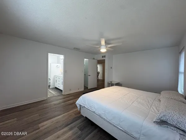 a spacious bedroom with a bed and a mirror