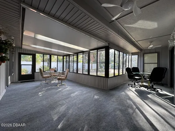 a living room with furniture and large windows