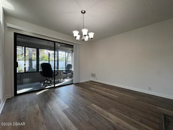 a view of a room with wooden floor and large windows
