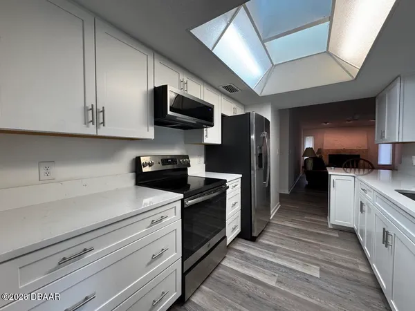 a kitchen with stainless steel appliances a stove microwave and cabinets