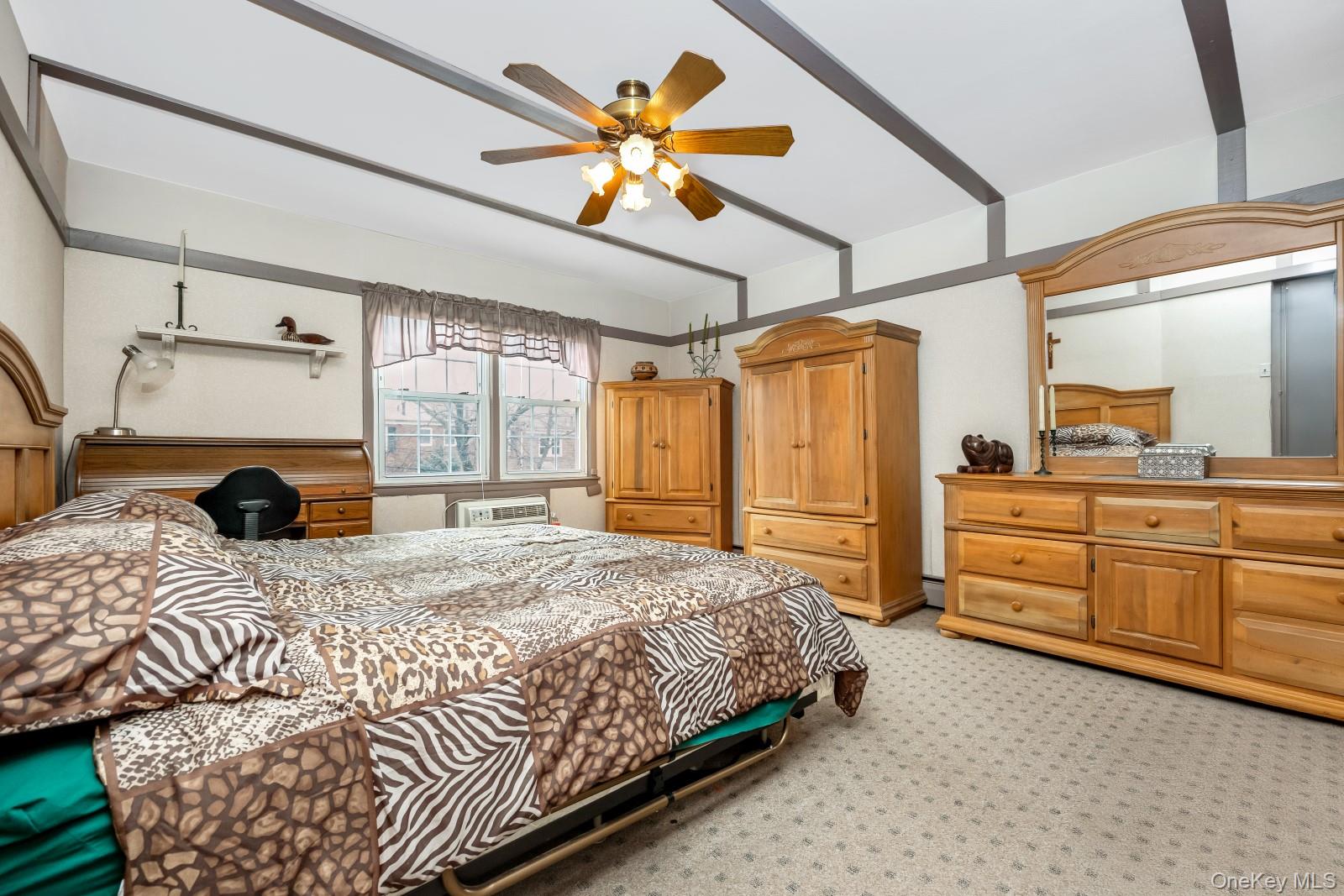 69-31 61st Road Queens, NY 11379 - Photo 14 of 28 a spacious bedroom with a bed a dresser and a chandelier