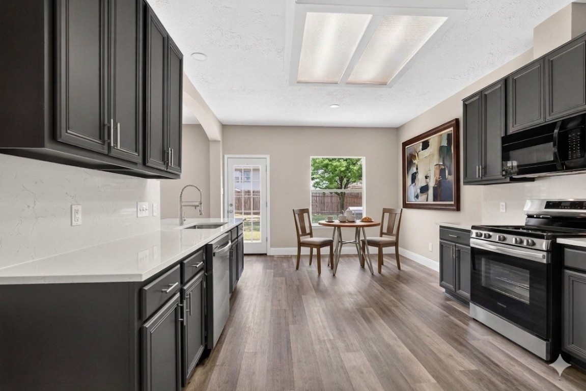 20926 Trellis Lane Houston, TX 77073 - Photo 12 of 22 Beautifully renovated kitchen boasts laminate flooring, brand new appliances, and space for a breakfast table (virtually staged).