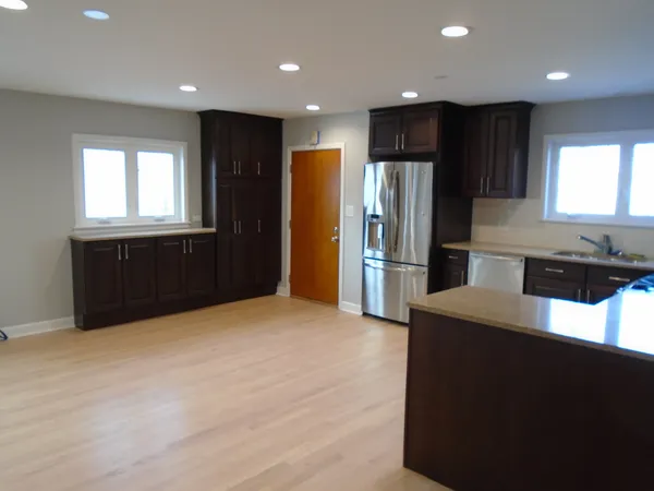 a kitchen with granite countertop a refrigerator and a stove top oven