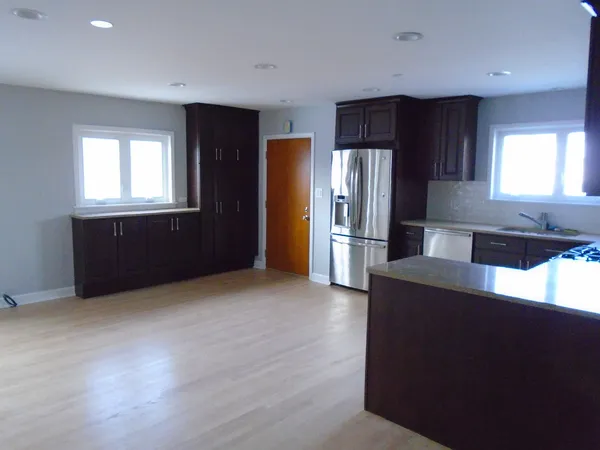 a kitchen with granite countertop a refrigerator and a stove top oven
