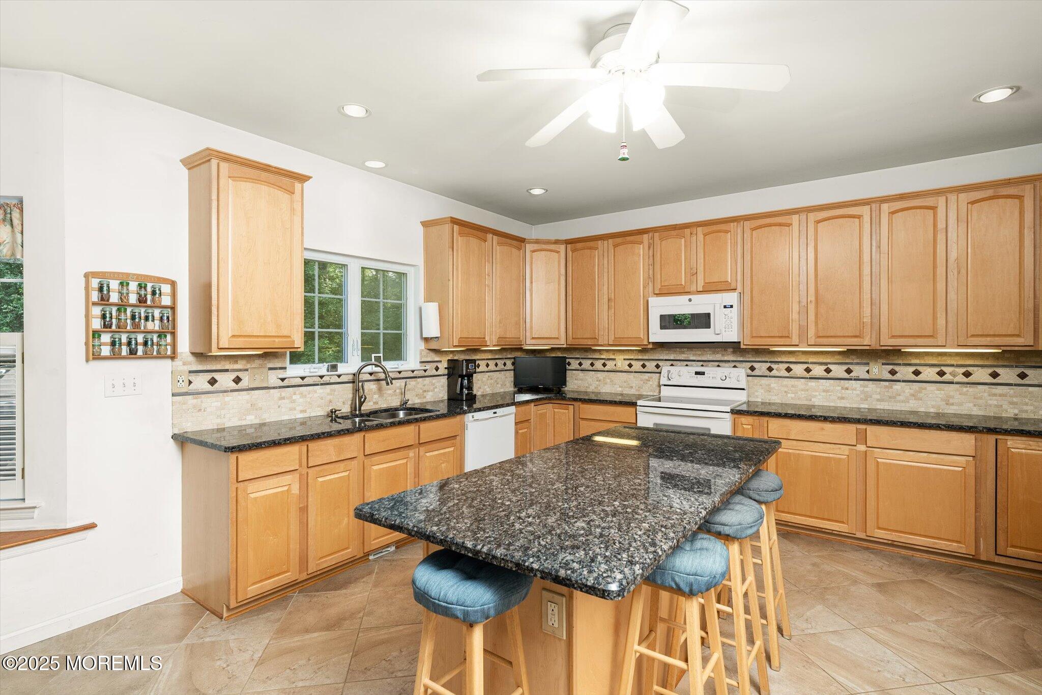 90 Sanders Lane Cream Ridge, NJ 08514 - Photo 14 of 48 a kitchen with stainless steel appliances granite countertop a stove a sink a microwave a dining table and chairs