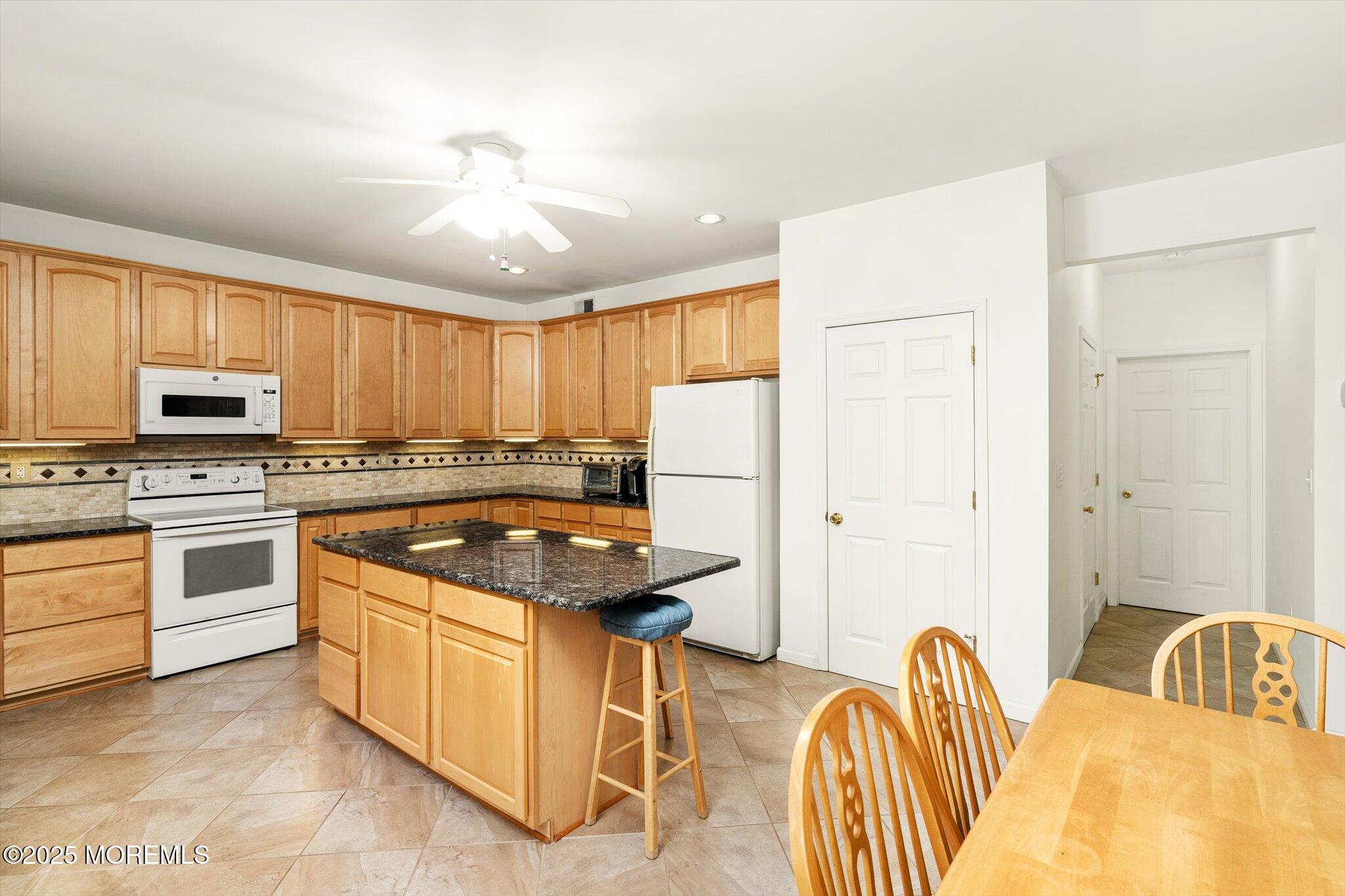 90 Sanders Lane Cream Ridge, NJ 08514 - Photo 15 of 48 a kitchen with stainless steel appliances granite countertop a stove refrigerator a sink dishwasher with a dining table and chairs
