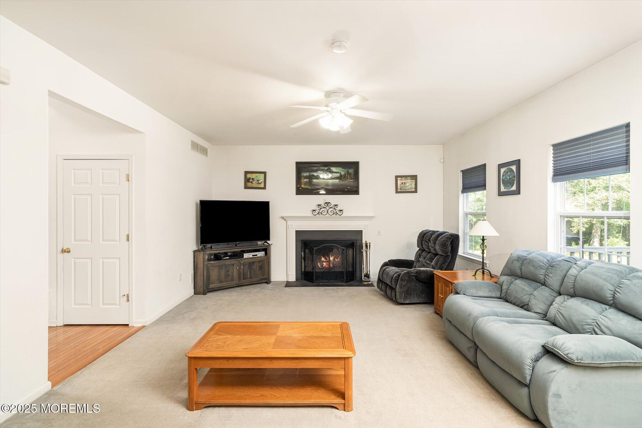 90 Sanders Lane Cream Ridge, NJ 08514 - Photo 9 of 48 a living room with furniture a flat screen tv and a fireplace