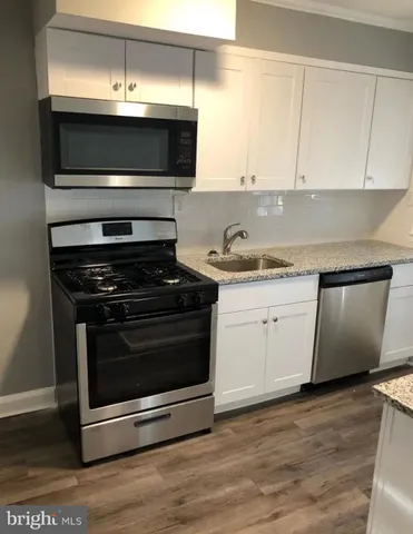 a kitchen with granite countertop a stove and a sink