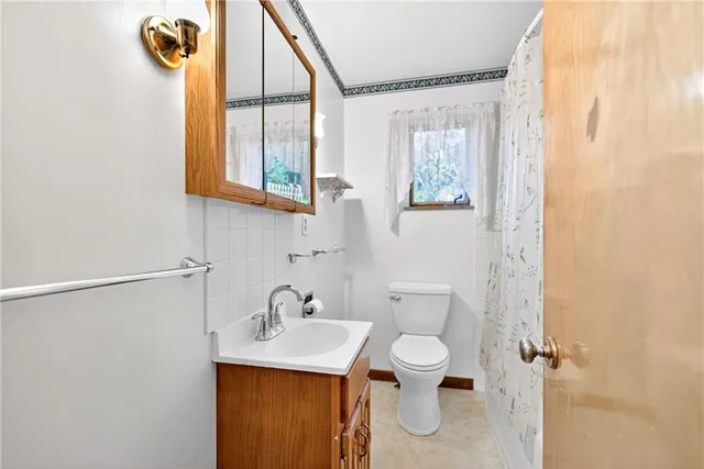 a bathroom with a toilet sink and mirror