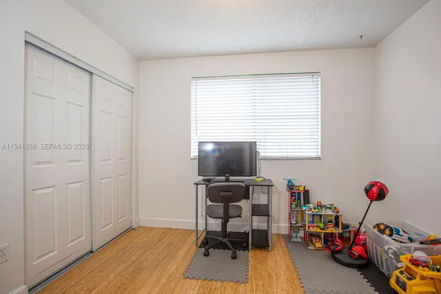 a view of a workspace with furniture and a window