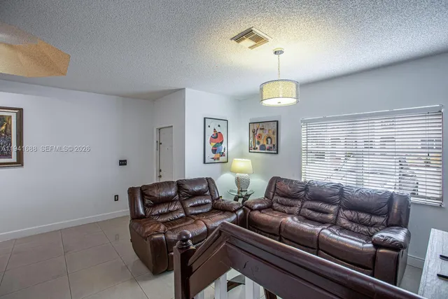 a living room with furniture a chandelier and a window