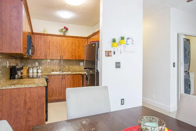 a kitchen with stainless steel appliances granite countertop a refrigerator and a stove top oven