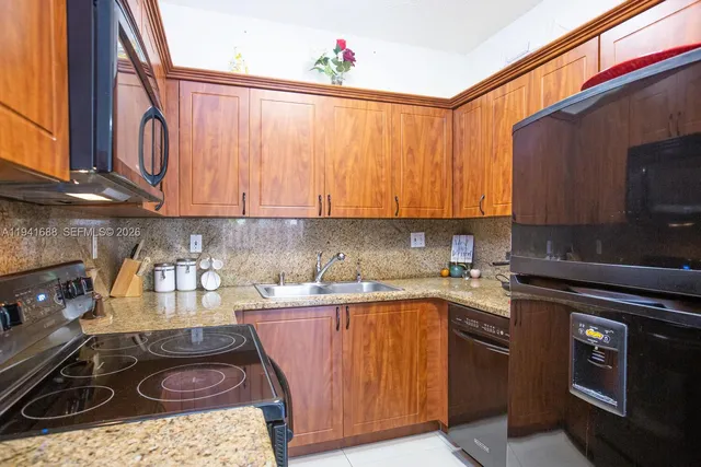 a kitchen with a sink a stove and cabinets