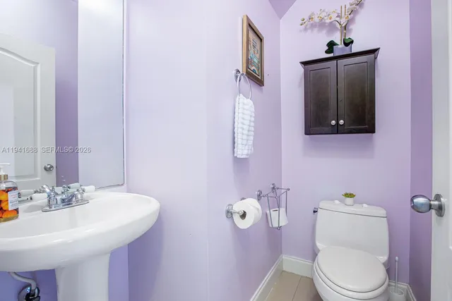 a bathroom with a toilet sink vanity and mirror