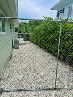 a view of a hallway with wooden floor and a bathroom