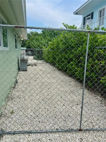 a view of a hallway with wooden floor and a bathroom