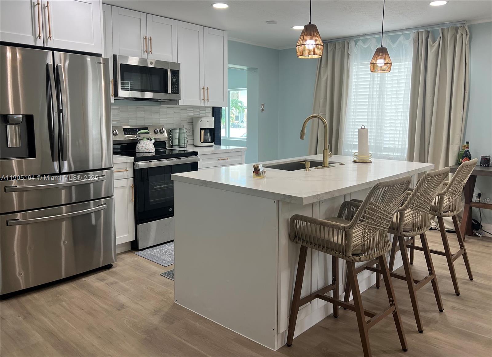 59 Tarpon Avenue Key Largo, FL 33037 - Photo 13 of 16 a kitchen with stainless steel appliances a table chairs sink and microwave