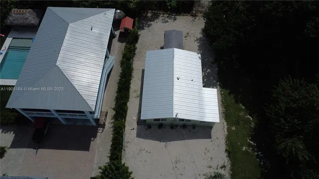 a kitchen with stainless steel appliances a dining table chairs refrigerator and microwave