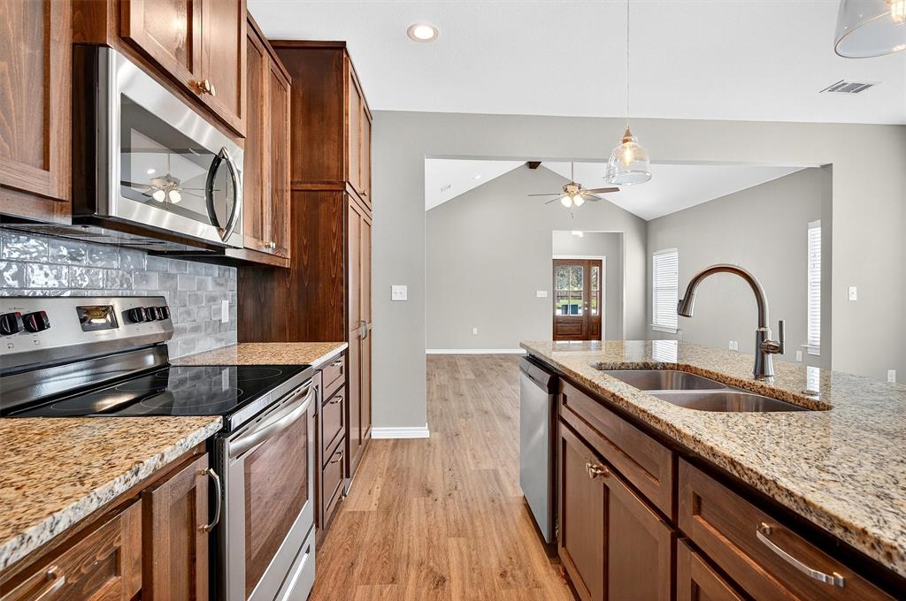 508 Goodjohn Street Collinsville, TX 76233 - Photo 14 of 40 Kitchen with appliances with stainless steel finishes, ceiling fan, light wood finished floors, lofted ceiling, and recessed lighting